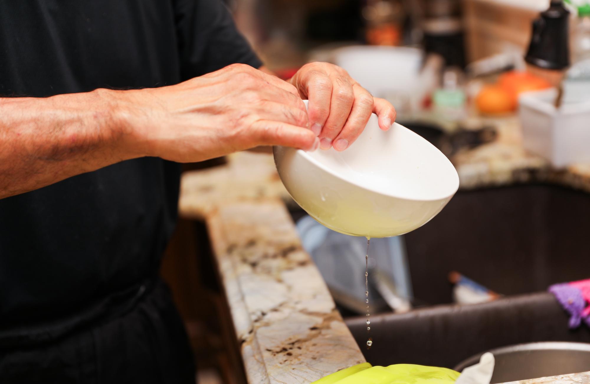 Chef hands preparing plated dish on ceramic